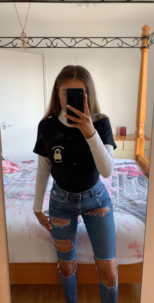 Image of me in the second outfit I described as a turtleneck paired with ripped jeans and a tee shirt over top